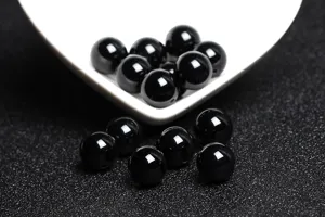 Macro detail view of polished natural black agate round beads for DIY jewelry making.