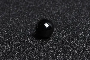 Macro shot of a single high-gloss natural black agate bead for DIY jewelry making projects.