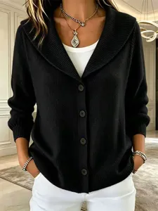 Close-up detail of stylish black knit cardigan featuring shawl collar and chic buttons.