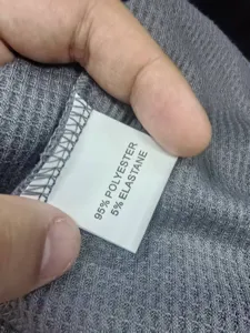 Nahaufnahme des Stoffzusammensetzungsetiketts mit 95% Polyester und 5% Elastan.