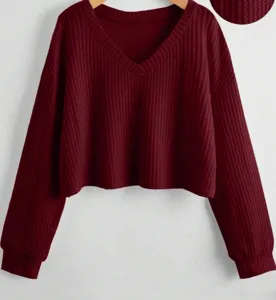 Dettaglio top corto a maniche lunghe con scollo a V in maglia waffle bordeaux con tessuto.