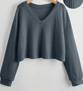 Top corto a maniche lunghe con scollo a V in maglia waffle grigio scuro, stile autunnale.