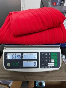 Ensemble de loungewear en tricot rouge sur balance pour vérification du poids.