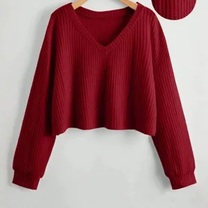 Top corto rosso in maglia waffle con scollo a V, pullover a maniche lunghe su gruccia.