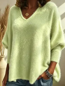 Close-up detail of women's V-neck fuzzy knit long sleeve sweater in light green cozy style