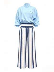 Close-up detail view of the light blue mock neck top and vertical striped trousers set.