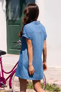 Vista di dettaglio dell'abito camicia in denim a maniche corte azzurro all'aperto.