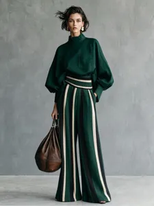 Detailed view of the elegant dark green long-sleeve top and striped wide-leg pants outfit.