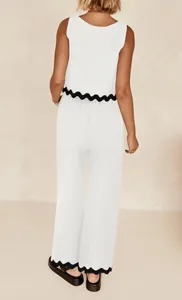 Close-up detail view of the white two-piece set featuring stylish black scalloped hems.