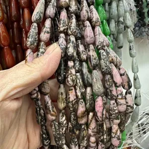 Détail en gros plan de perles en pierre naturelle de rhodonite 8x20mm pour la joaillerie