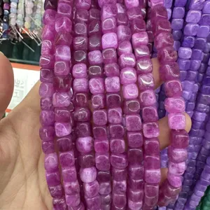 Dettaglio macro di perle di agata naturale quadrata viola da 8 mm per gioielli fai da te.