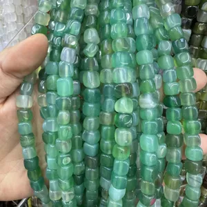 Primo piano di perle in calcedonia verde quadrate da 8 mm per gioielli fai-da-te.