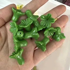 Close-up detail of green trumpet flower-shaped loose beads for DIY jewelry crafts