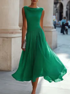Detail shot of the elegant green cowl neck sleeveless dress showing draped fabric texture outdoors.