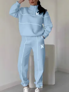 Light blue half-zip sweatshirt and sweatpants tracksuit set with white piping and letters.
