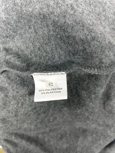 Close-up detail of women trousers fleece fabric and size label S polyester elastane blend