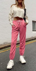 Close-up detail of women's high-waist pink sweatpants featuring a white drawstring and cuffed hem.