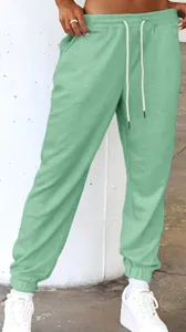 Mint green casual sweatpants detail shot featuring elastic drawstring waistband and cuffed hem.