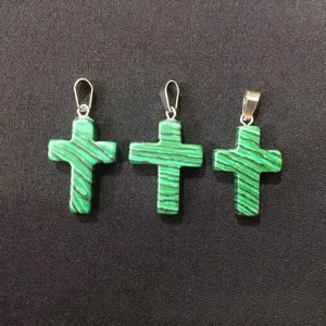 Detail shot of three malachite-patterned stone cross pendants with silver bails.