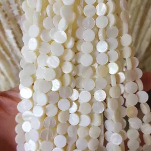 Close-up of white freshwater shell round disc beads with natural pearl luster