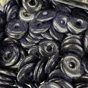 Detailed view of 25mm blue goldstone donut beads showing glittery sandstone texture