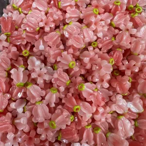 Detalle macro de cuentas de flores de polvo de concha rosa con centro verde para crear joyería DIY