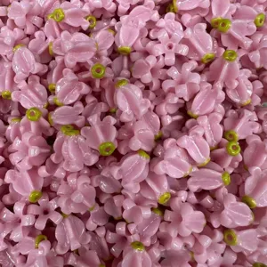 Primer plano de cuentas de flores corona rosas con agujeros verdes para crear joyas