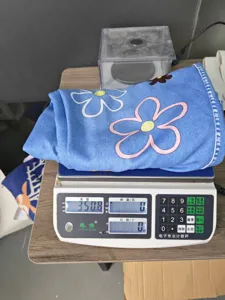 Detailed view of the blue floral fabric product being weighed, showing clear texture and quality.