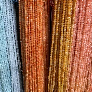 Close-up of faceted natural stone beads in blue, amber, and pink for DIY jewelry