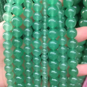 Detailed close-up view of green translucent Malay jade chalcedony round beads for DIY