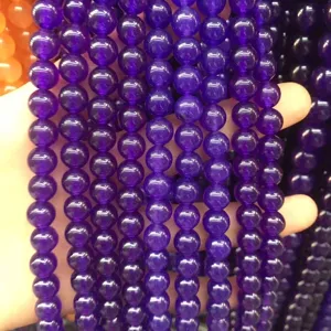 High-quality detailed close-up of natural purple chalcedony round beads for DIY jewelry
