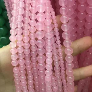 Detailed view of polished pink natural stone chalcedony round beads for jewelry making