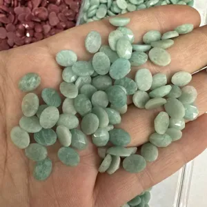 Dettaglio macro di cabochon ovali sfaccettati in pietra naturale verde chiaro per gioielli.