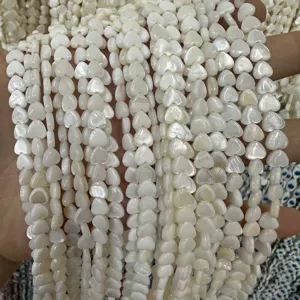 Nahaufnahme weißer herzförmiger Süßwassermuschelperlen mit Perlmuttglanz für DIY