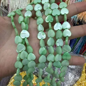 Close-up of light green heart-shaped mother of pearl beads for DIY jewelry making