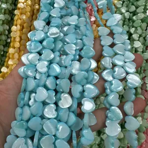 Detail view of colorful heart-shaped mother of pearl shell beads with iridescent luster finish