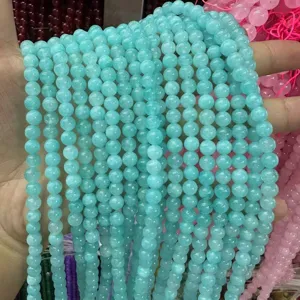 Primer plano de cuentas redondas de amazonita azul claro para crear joyas DIY.