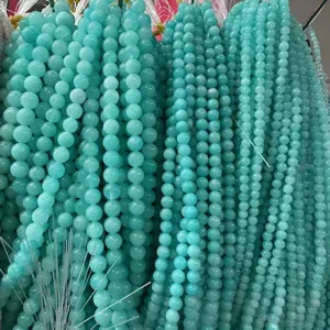 Detalle de cuentas redondas sueltas de amazonita verde azulado para crear joyas DIY