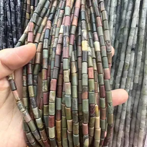 Close-up of multi-colored cylindrical natural stone beads showing earthy textures