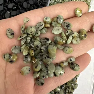 Primo piano di pietre naturali verdi ovali con macchie nere per gioielli
