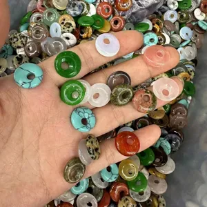 Close-up macro view of mixed natural stone Ping An Kou donut beads for DIY jewelry crafts