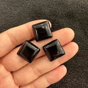 Nahaufnahme von drei polierten quadratischen schwarzen Onyx-Edelsteinen für DIY-Schmuck