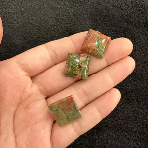 Nahaufnahme von drei polierten quadratischen Unakit-Naturstein-Cabochons für DIY-Schmuckherstellung