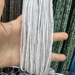 Detailed macro view of 2x2mm white natural stone cylindrical beads for DIY jewelry crafting