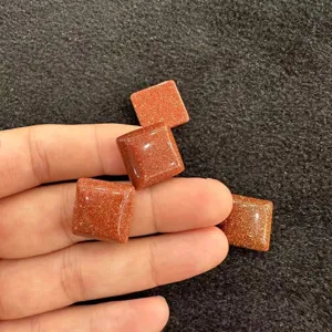 Nahaufnahme von funkelnden quadratischen Goldstein-Cabochons für DIY-Schmuckzubehör-Komponenten