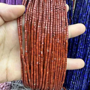 Macro detail view of 2x2mm red jasper cylinder natural stone beads for DIY jewelry making