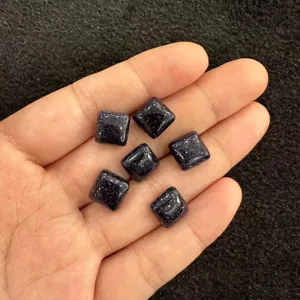 Nahaufnahme von funkelnden blauen Goldstein-Quadrat-Cabochons für DIY-Schmuckherstellung
