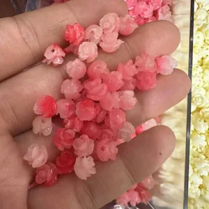 Close-up of pink shell powder embossed 3D rose beads with horizontal holes for DIY jewelry