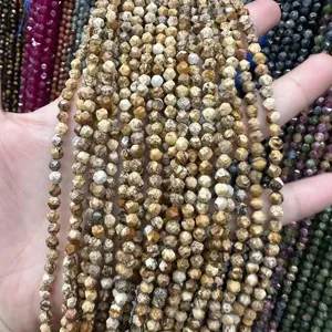 Détail macro de perles en pierre naturelle facettées de 4 mm aux motifs terreux beiges