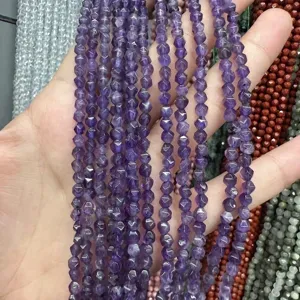 Gros plan macro de perles en pierre d'améthyste facettées naturelles de 4 mm pour bijoux DIY